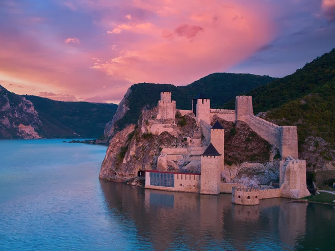 Aerial, across lake view of the medieval fortress Golubac over Danube river
