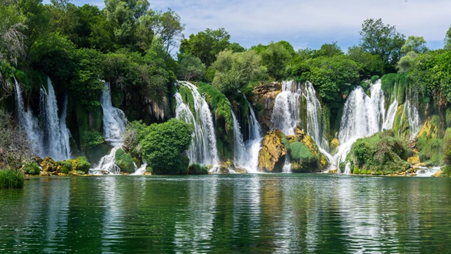 Small boat rowing just under Kravica waterfalls in southern Bosnia