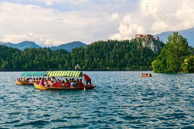 Traditional Pletna boats and tourists in the Lake Bled located in Slovenia